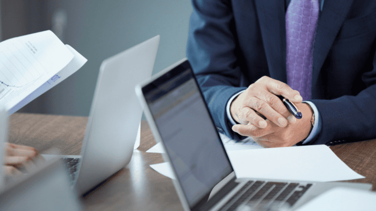 Law firm professional reviewing compliance filings and financial reports beside a laptop after the BOI reporting rule change