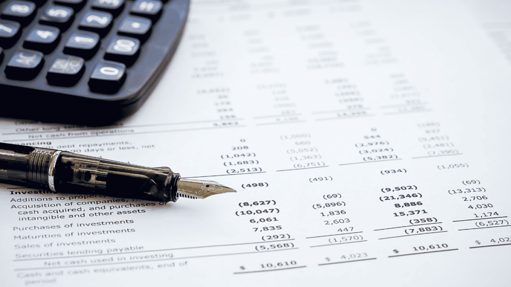 Fountain pen resting on a financial report showing detailed line-item figures, with a calculator nearby, representing the close review behind law firm financial KPIs