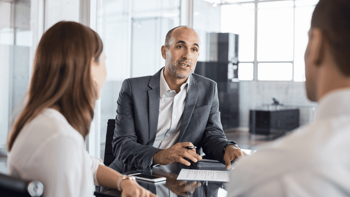 Advisor reviewing year-end financial planning decisions with law firm owners across the table during a Q4 strategy meeting